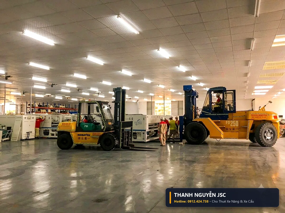 Cặp xe nâng Komatsu và Mitsubishi di chuyển song song trong gian xưởng công nghiệp chuẩn bị nâng tải