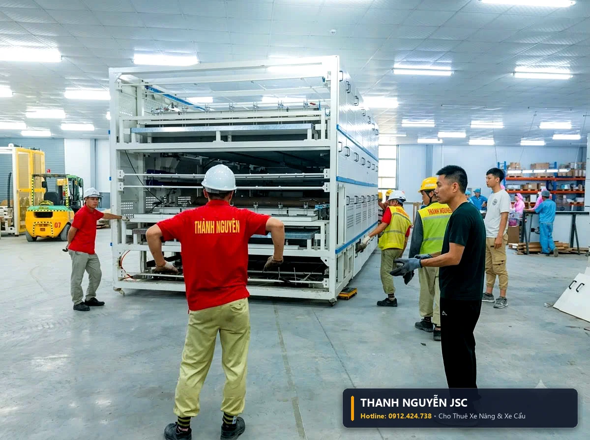 Kỹ sư an toàn THÀNH HUY HOÀNG tại Thái Bình áo đỏ hướng dẫn xe nâng di chuyển cụm khung giàn máy tự động nhiều tầng